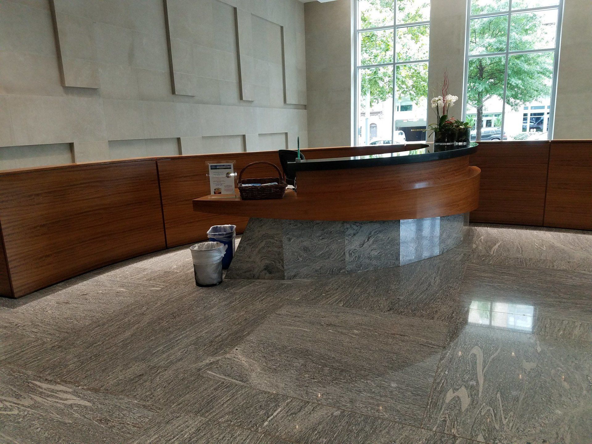 A lobby with a wooden counter and a marble floor
