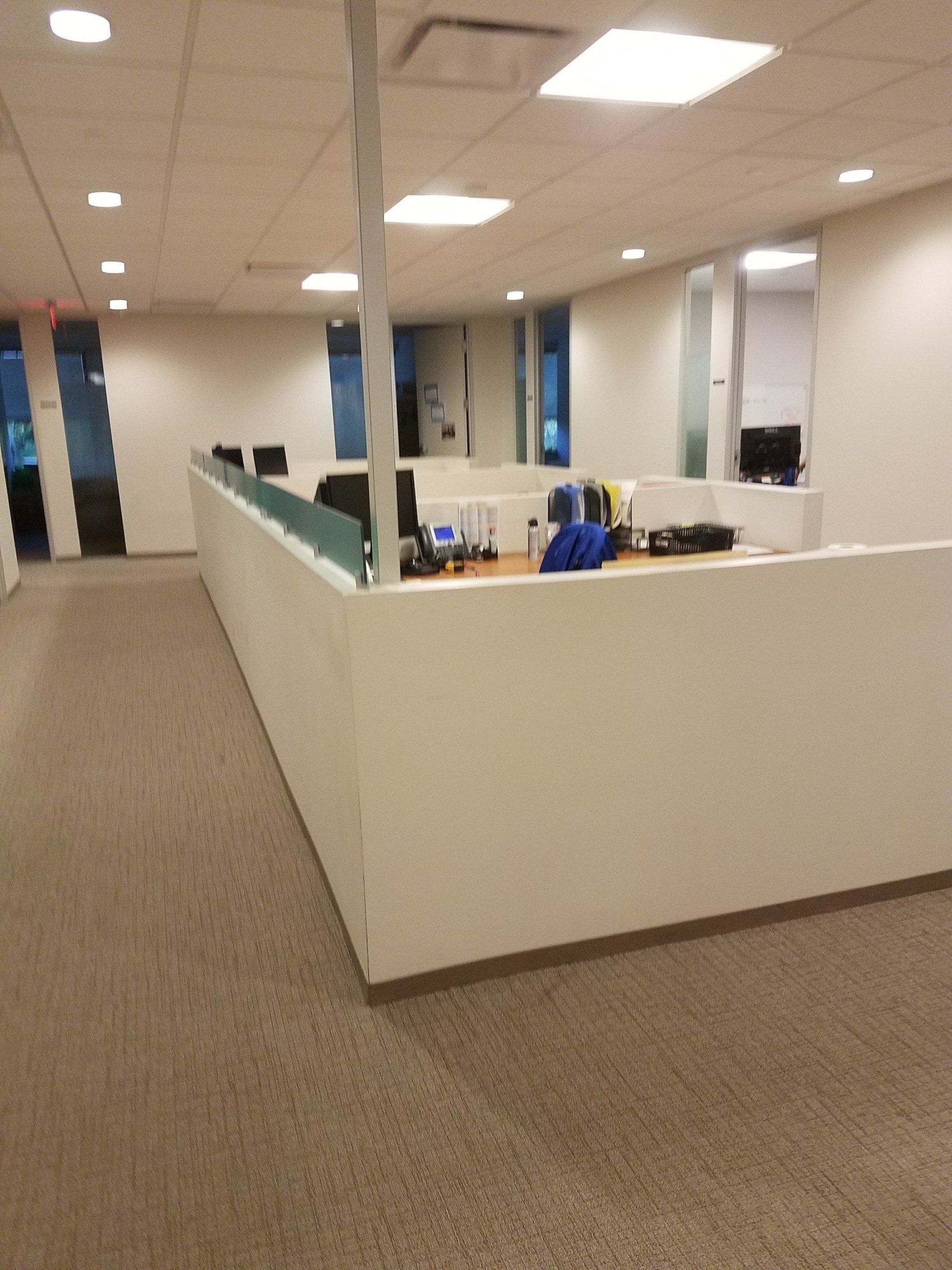 A large office with a carpeted floor and white walls