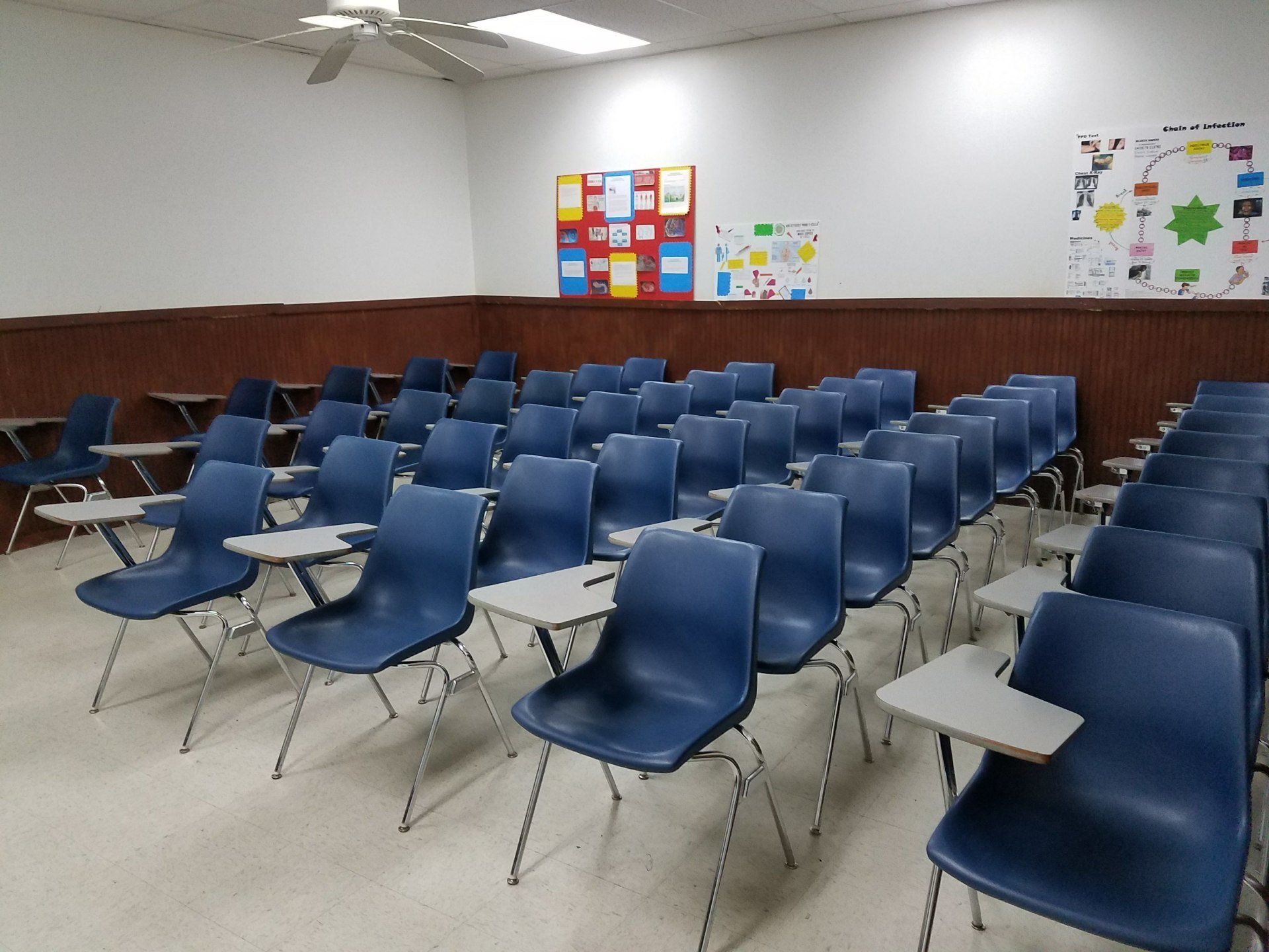 Rows of blue chairs with desks in a classroom