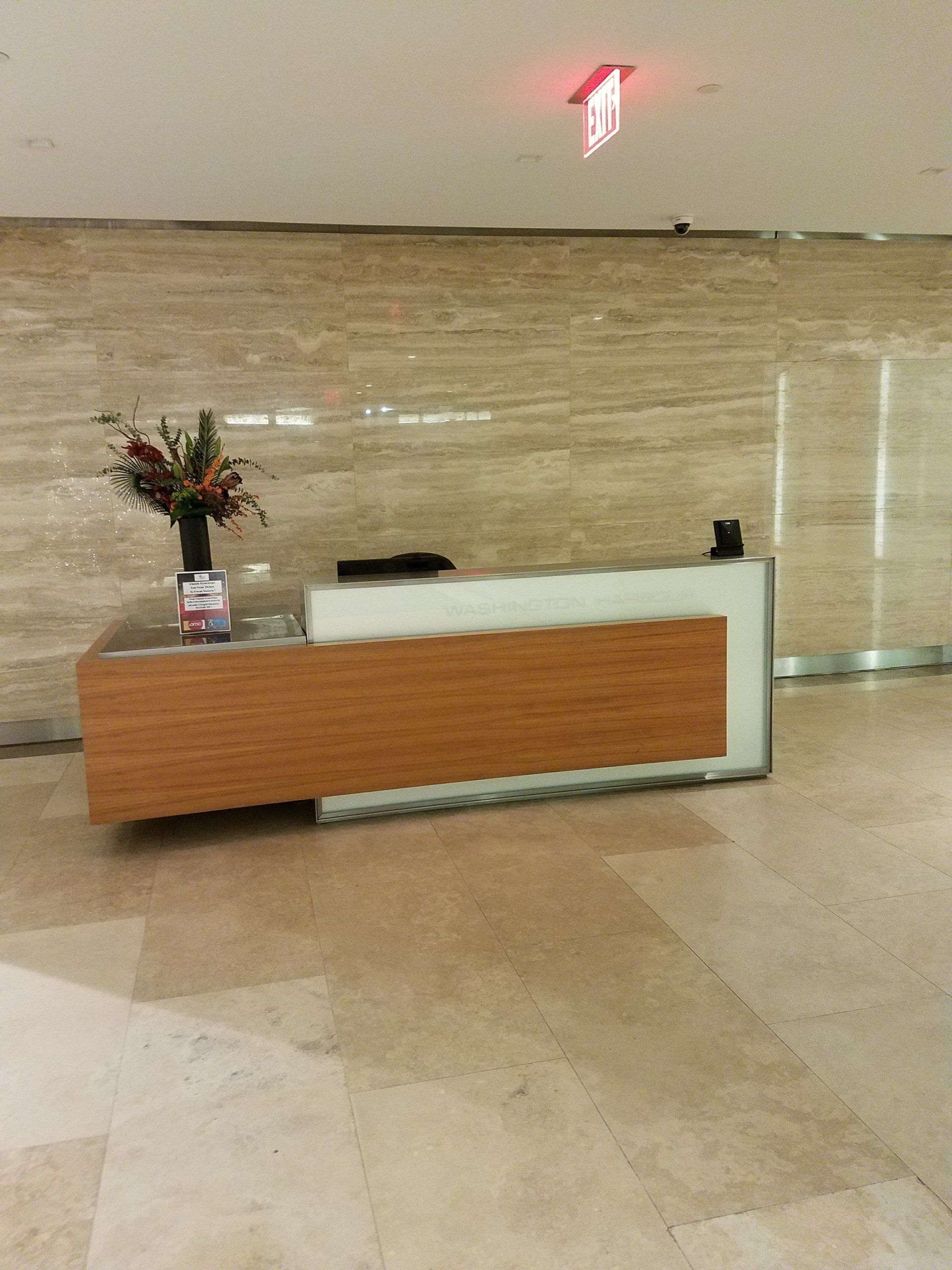 A reception desk with a vase of flowers on it