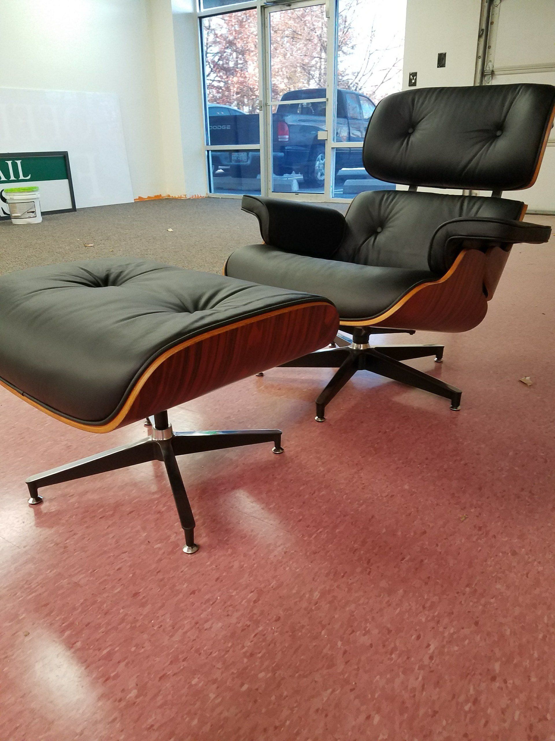 A chair and ottoman are sitting on a pink carpeted floor.
