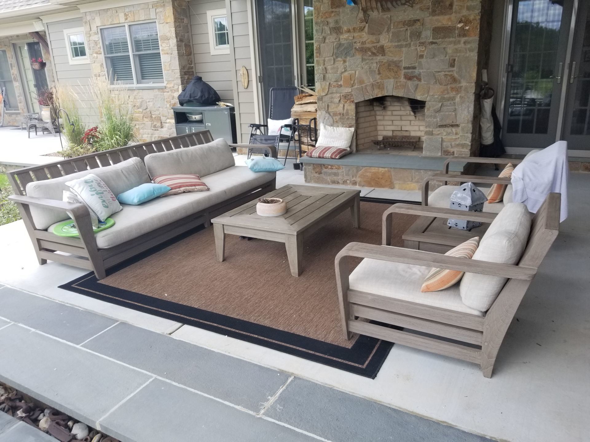 A patio with a couch and chairs and a fireplace