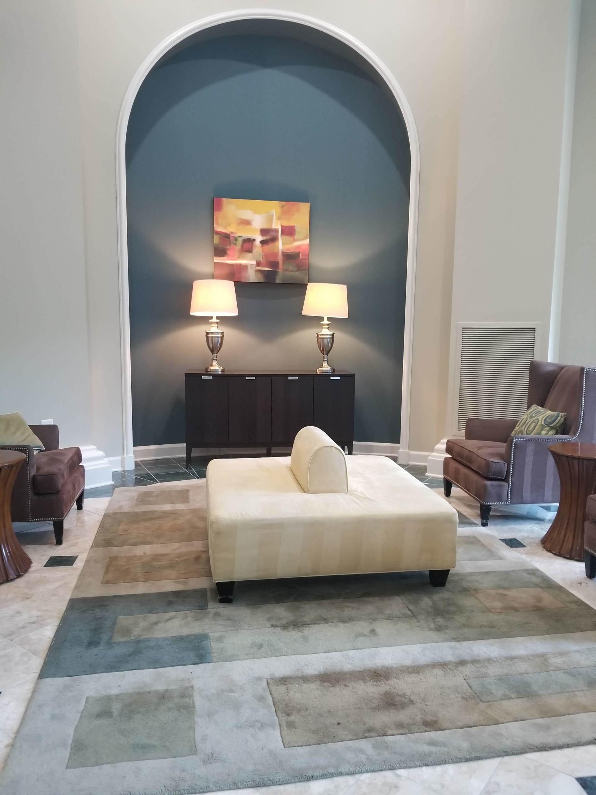 A living room with a couch and chairs and a rug