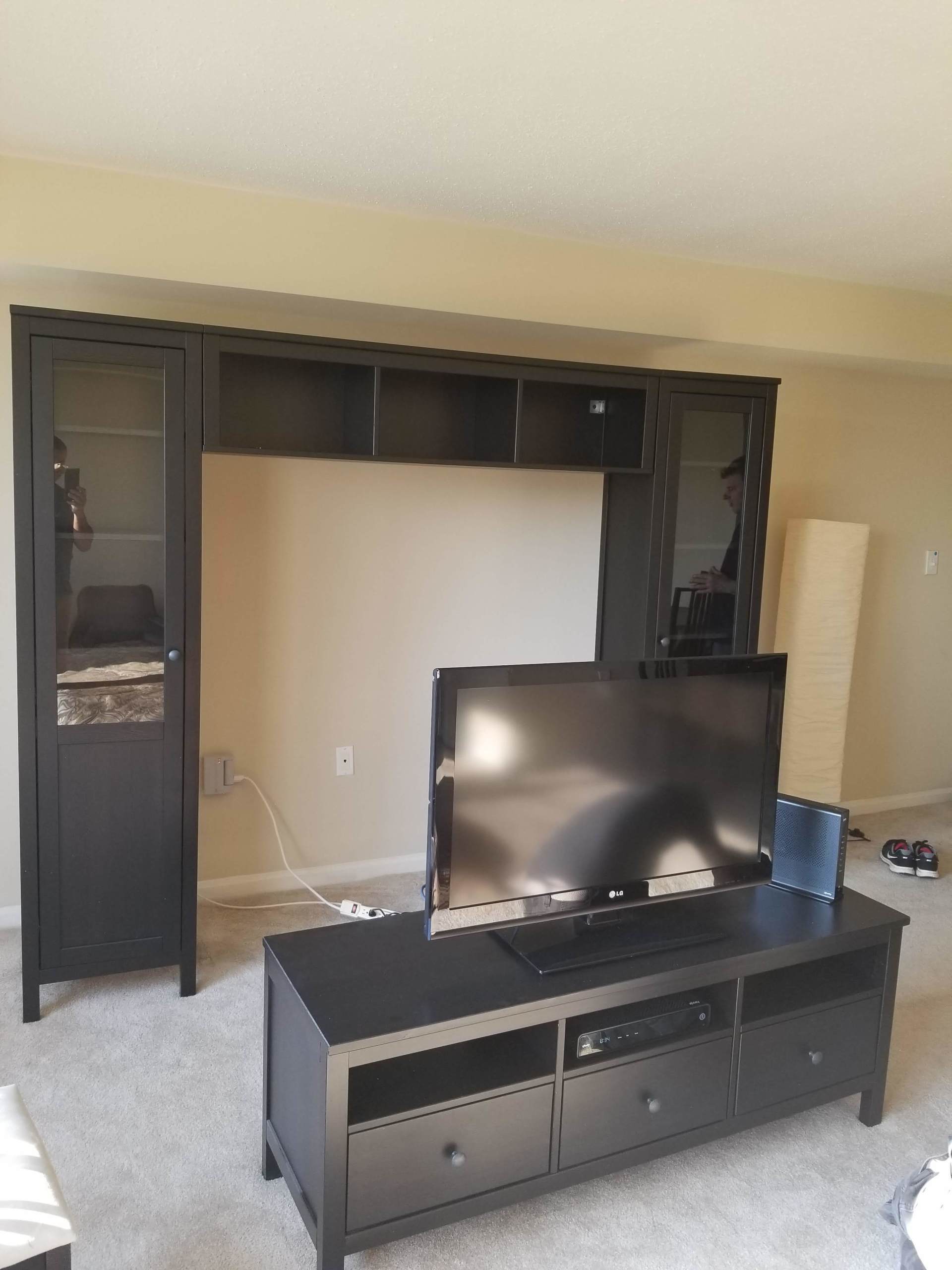 A living room with a black entertainment center and a flat screen tv