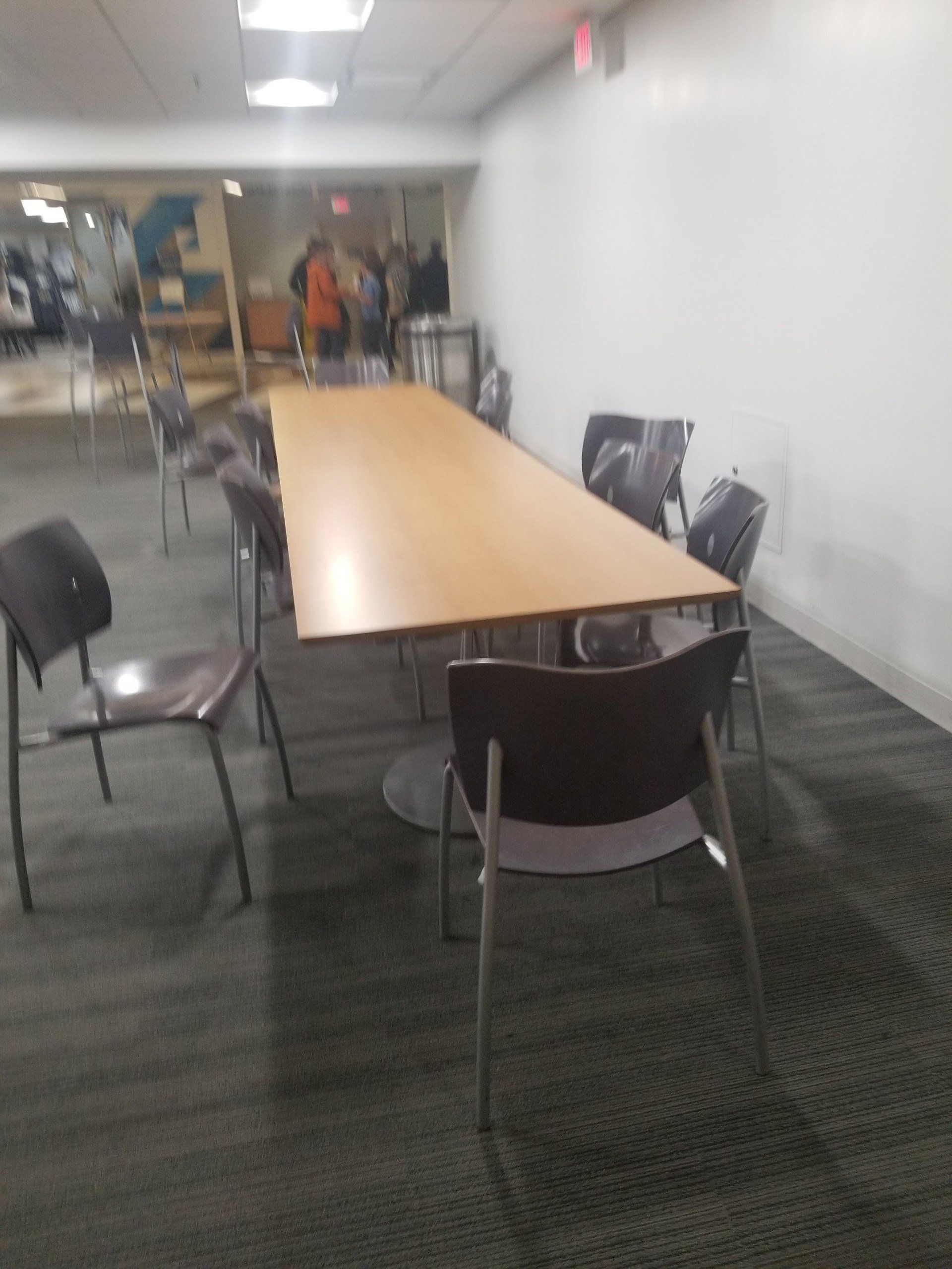 A room with a long table and chairs in it