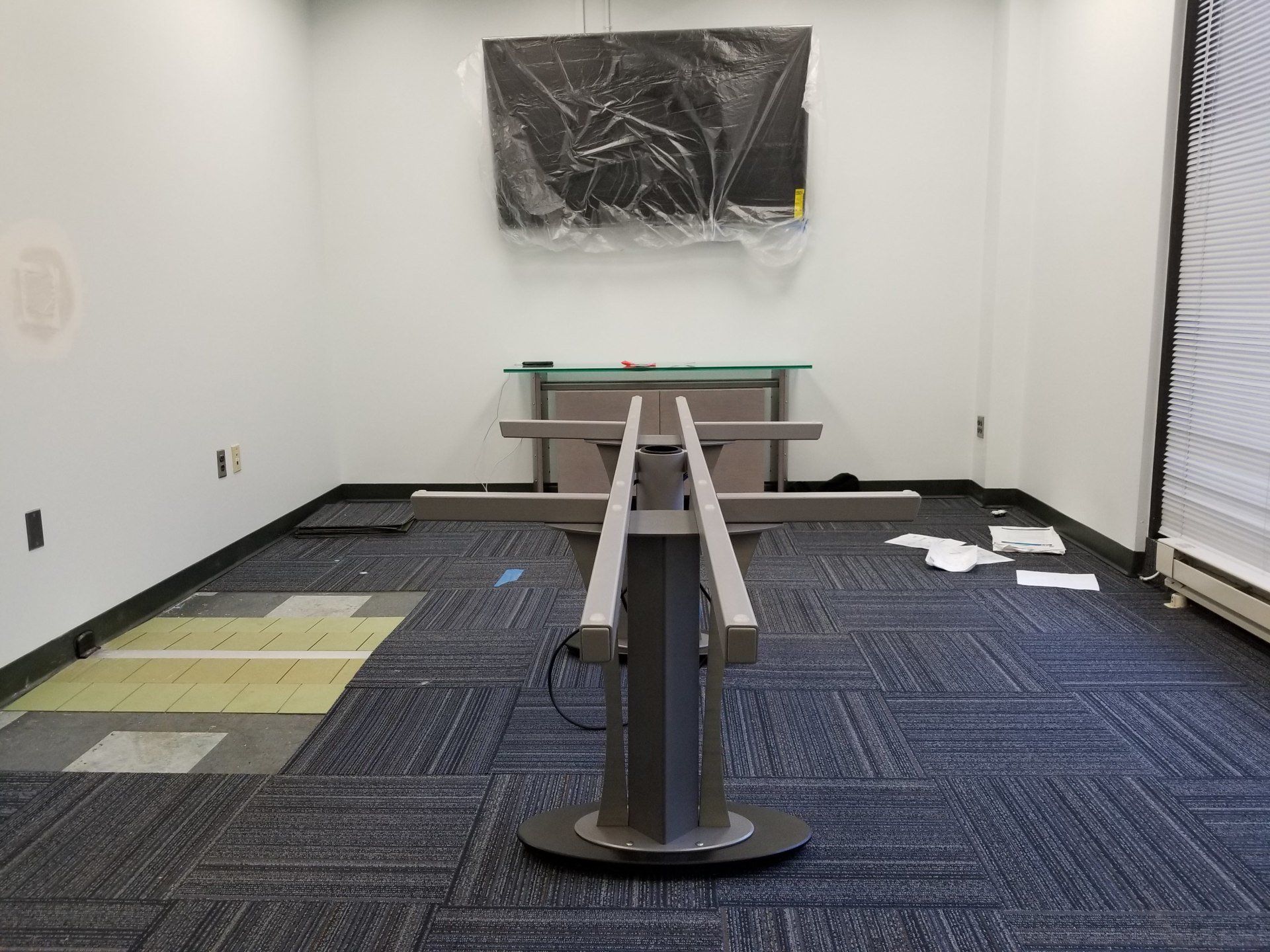 An empty room with a table in the middle of it.