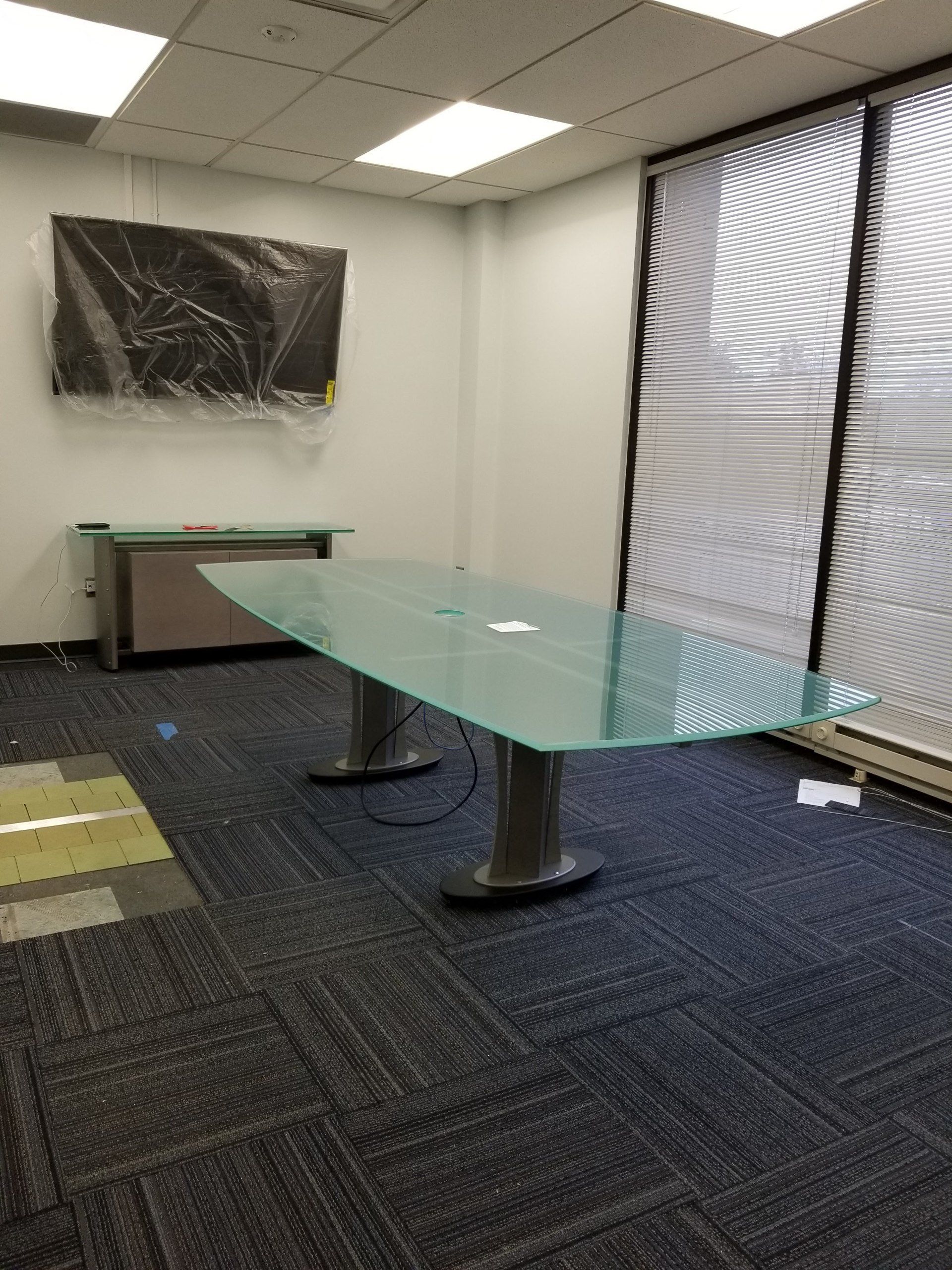 There is a glass table in the middle of the room.