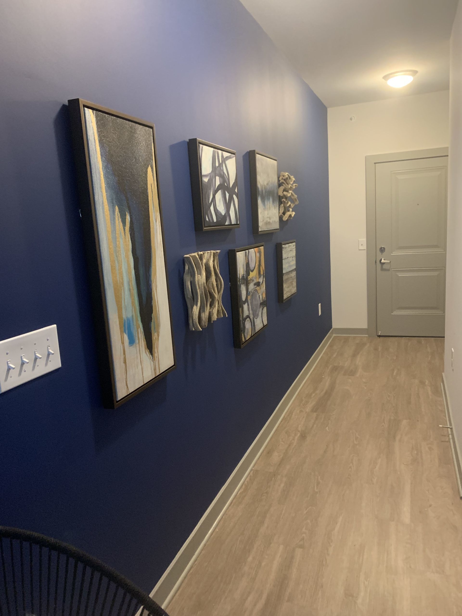 A hallway with blue walls and paintings on the wall