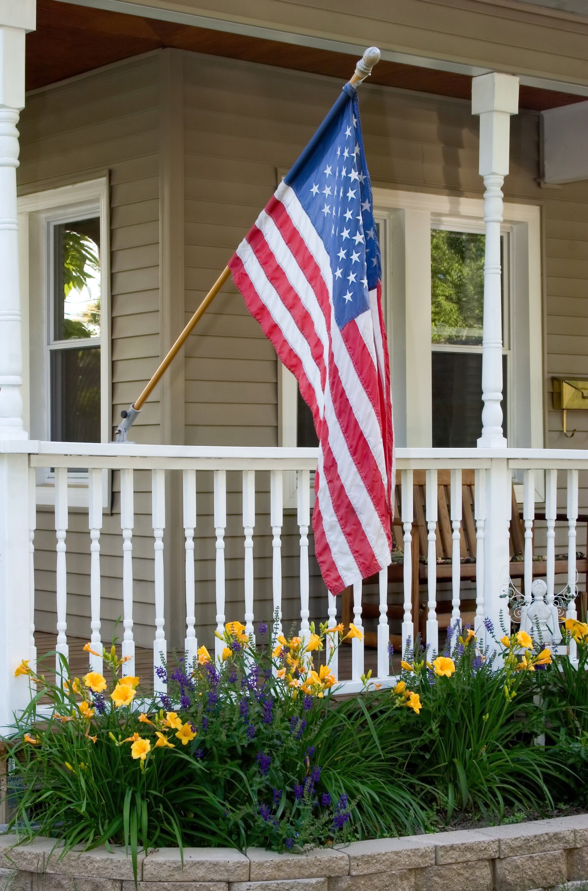 An american flag is flying on the porch of a house