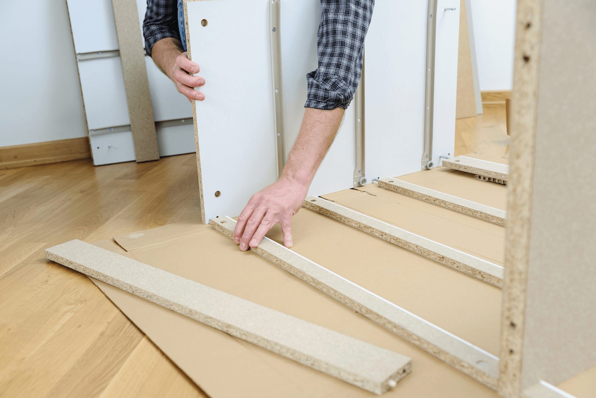 A gray shoe rack is sitting on a wooden floor in a room.