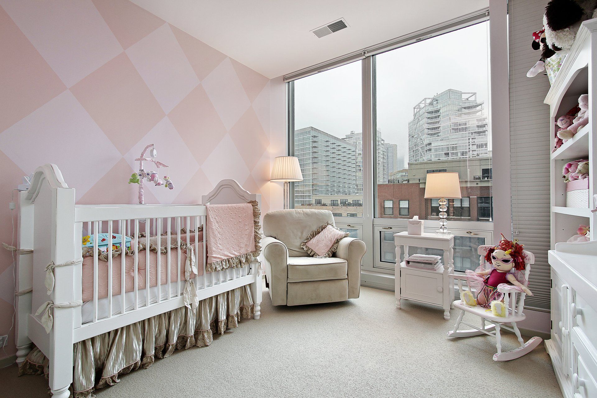 A baby 's room with a crib , rocking chair , and dresser.