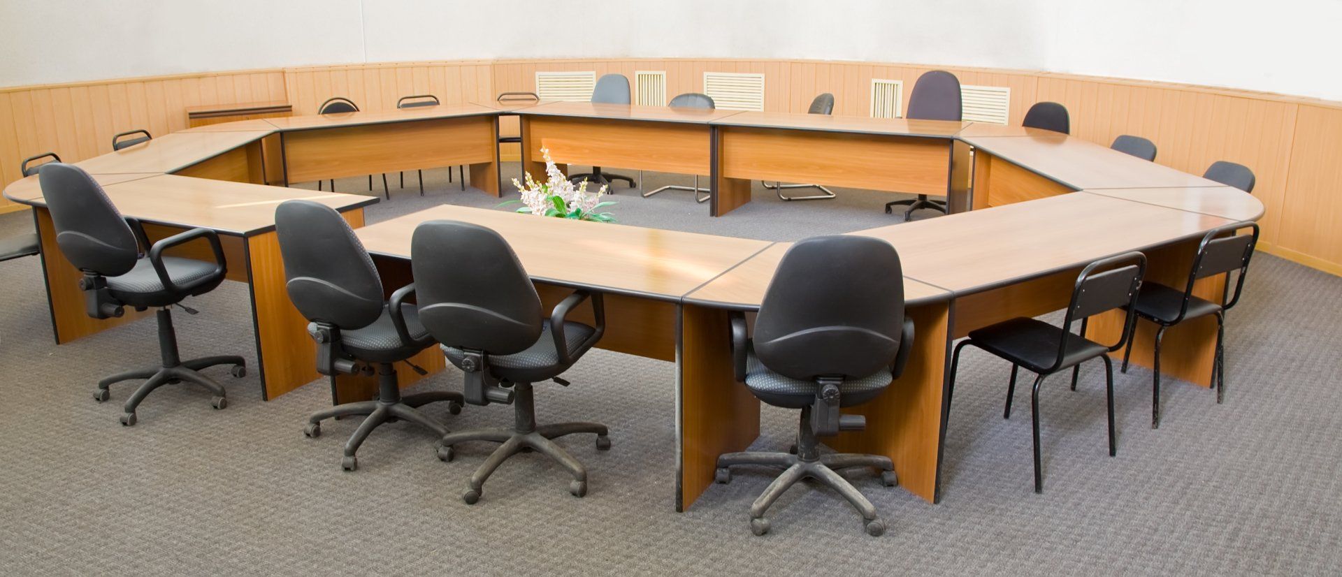 A conference room with tables and chairs arranged in a circle