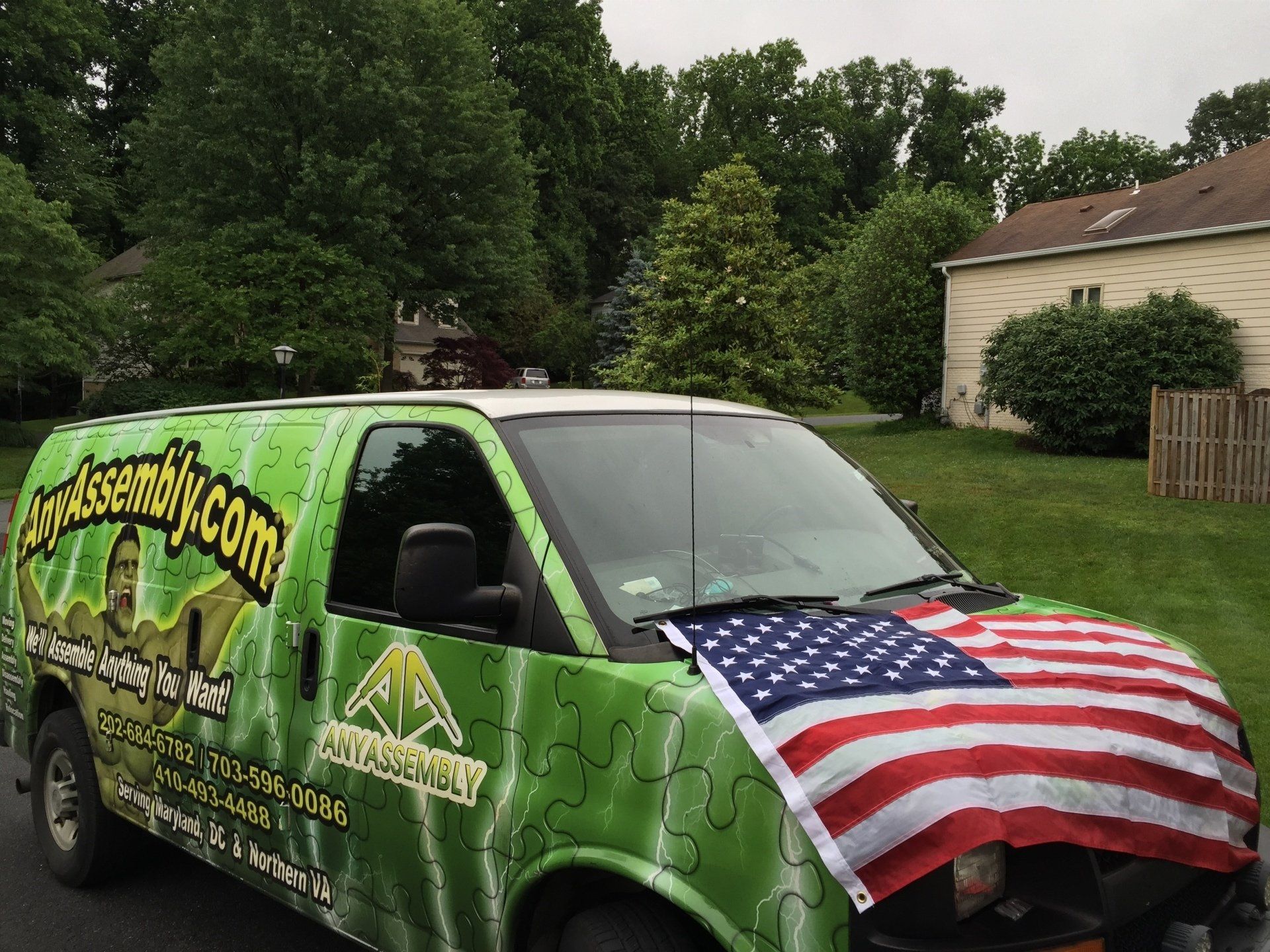 A green van with an american flag on the hood
