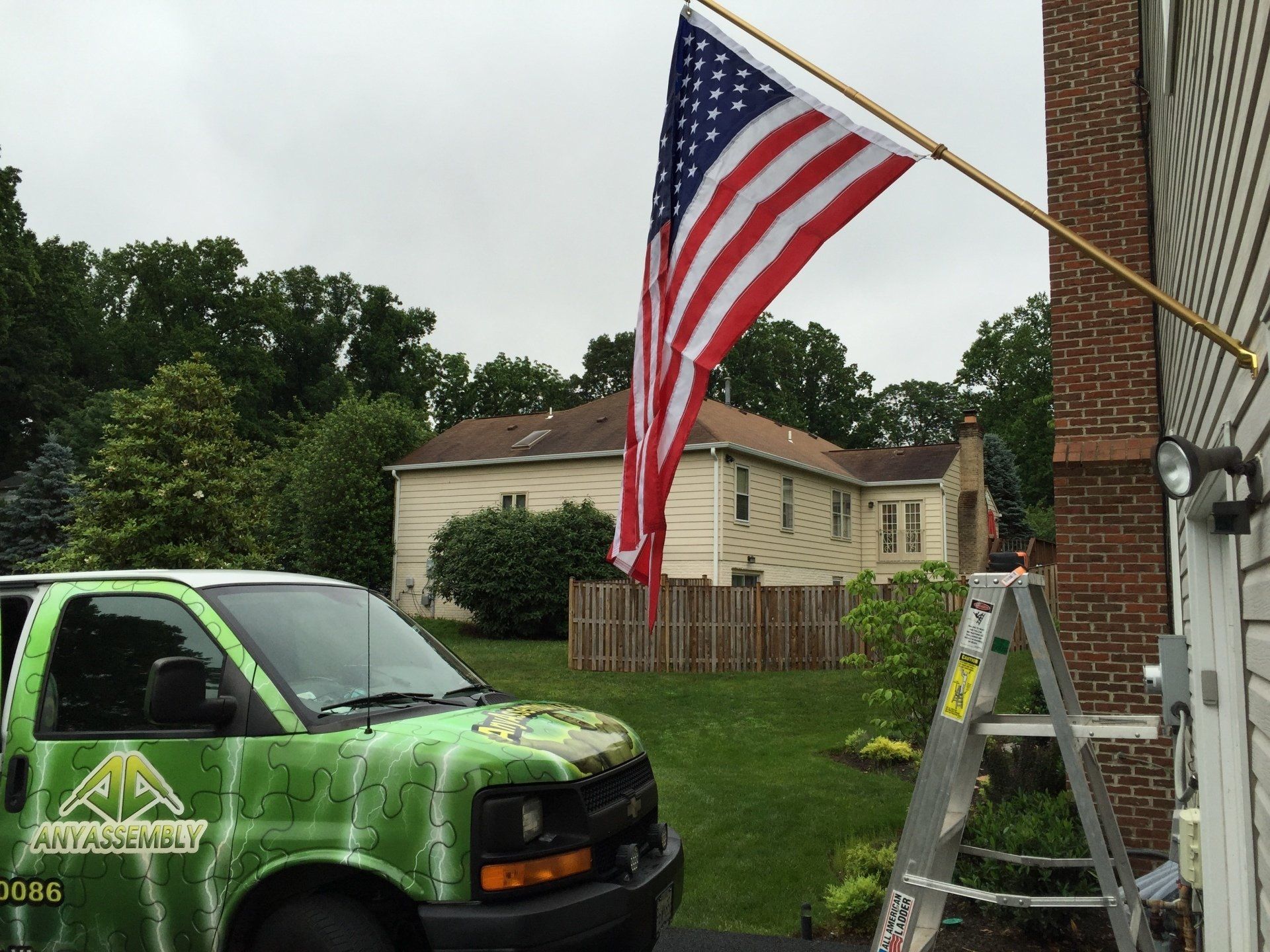 An american flag is flying in front of a green van