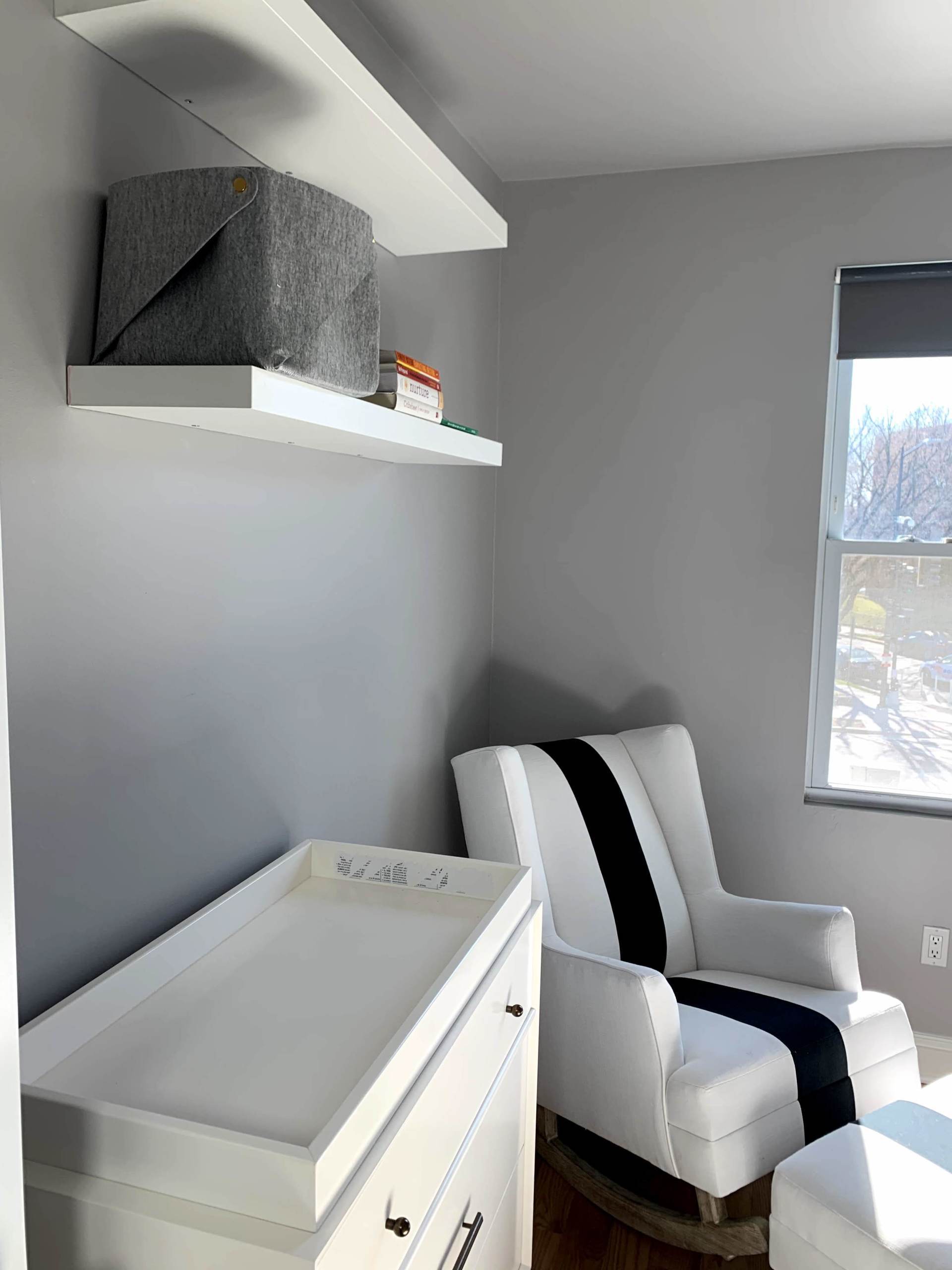 There is a rocking chair and a changing table in the room.