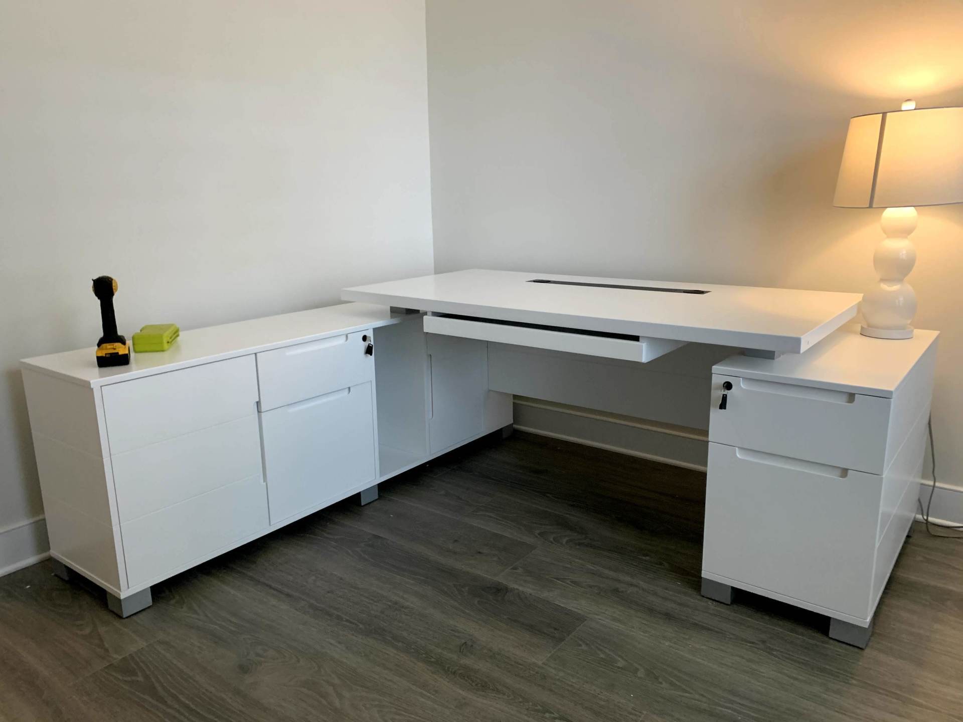 A white desk with a drawer underneath it in a room.
