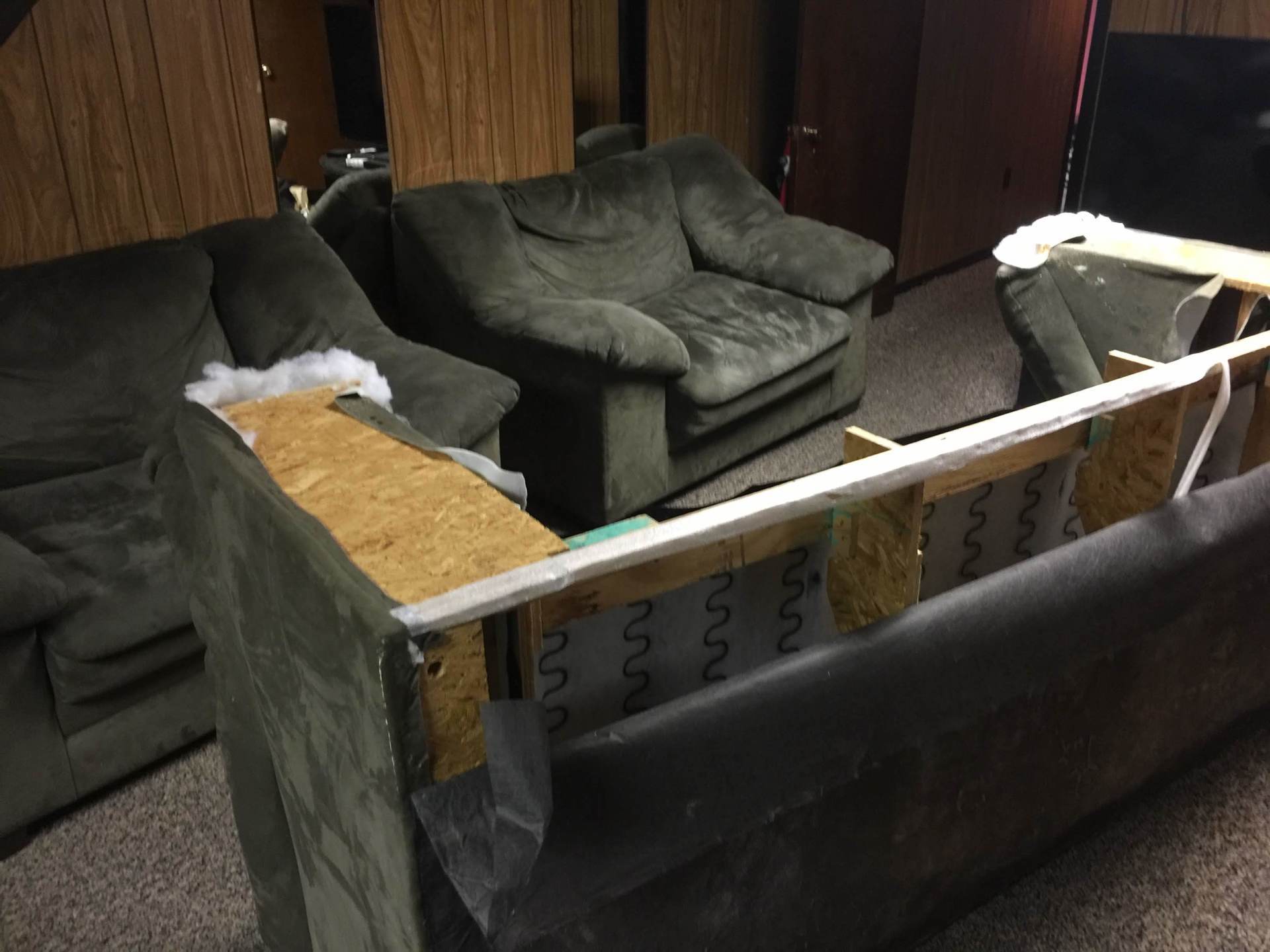 A couch is being dismantled in a living room
