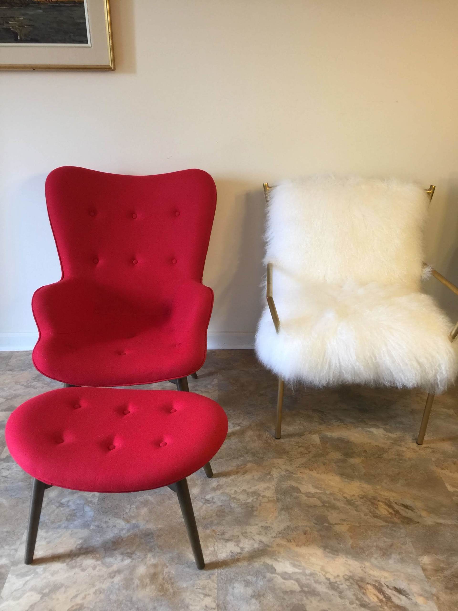 A red chair and a white chair are sitting next to each other in a room.