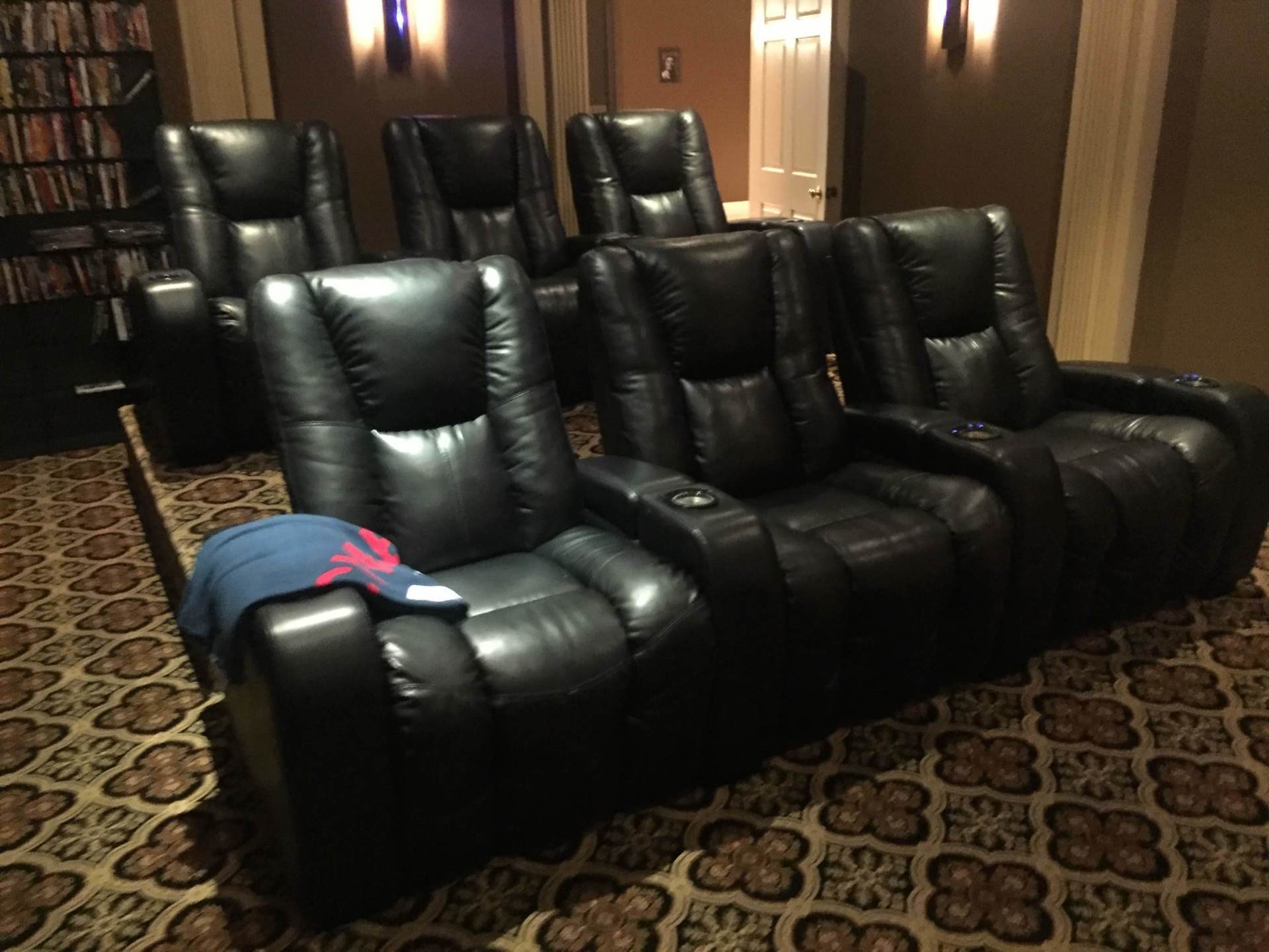 A row of black leather recliner seats in a home theater