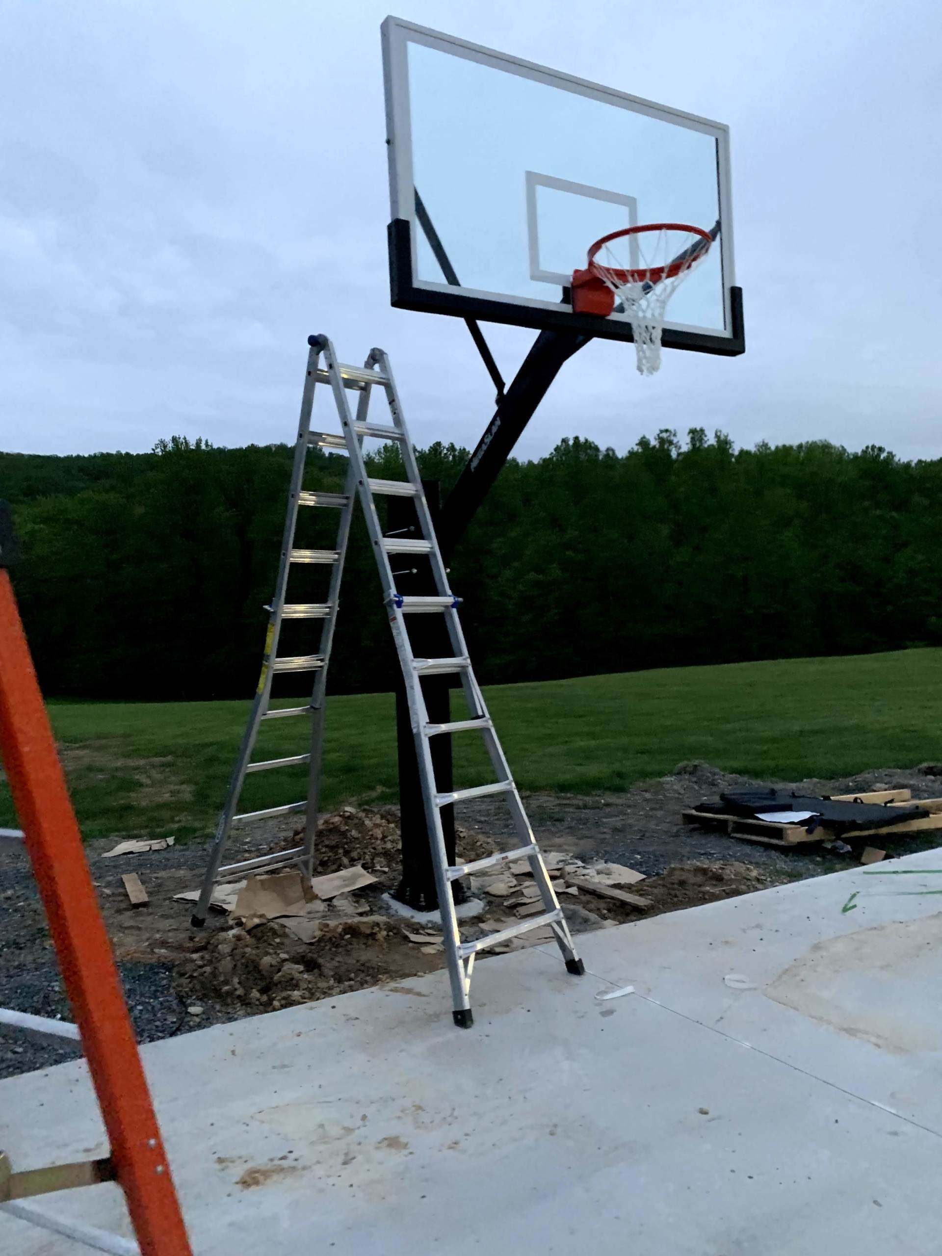 A ladder is sitting next to a basketball hoop