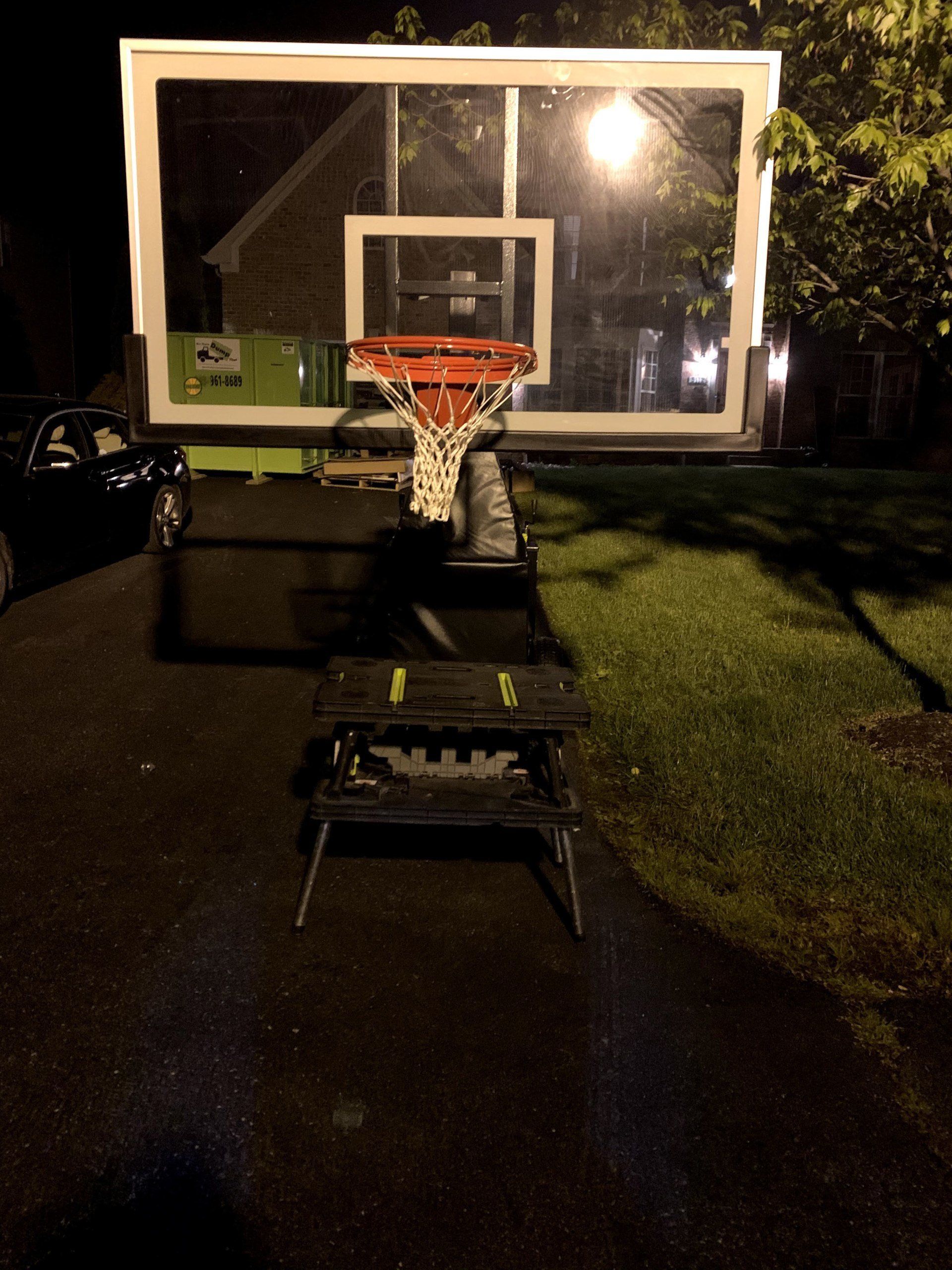 A basketball hoop in a driveway at night