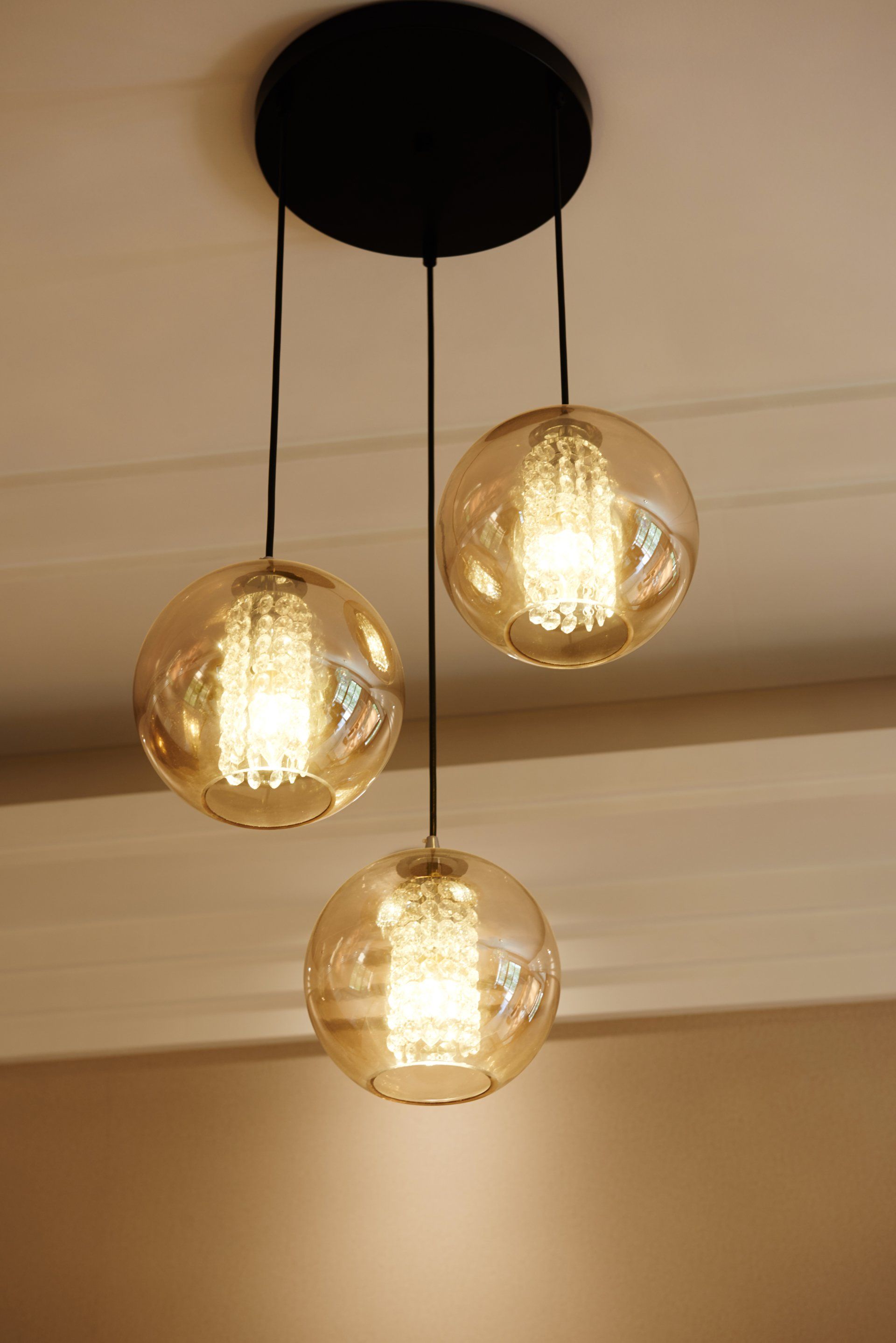 A close up of three pendant lights hanging from the ceiling.