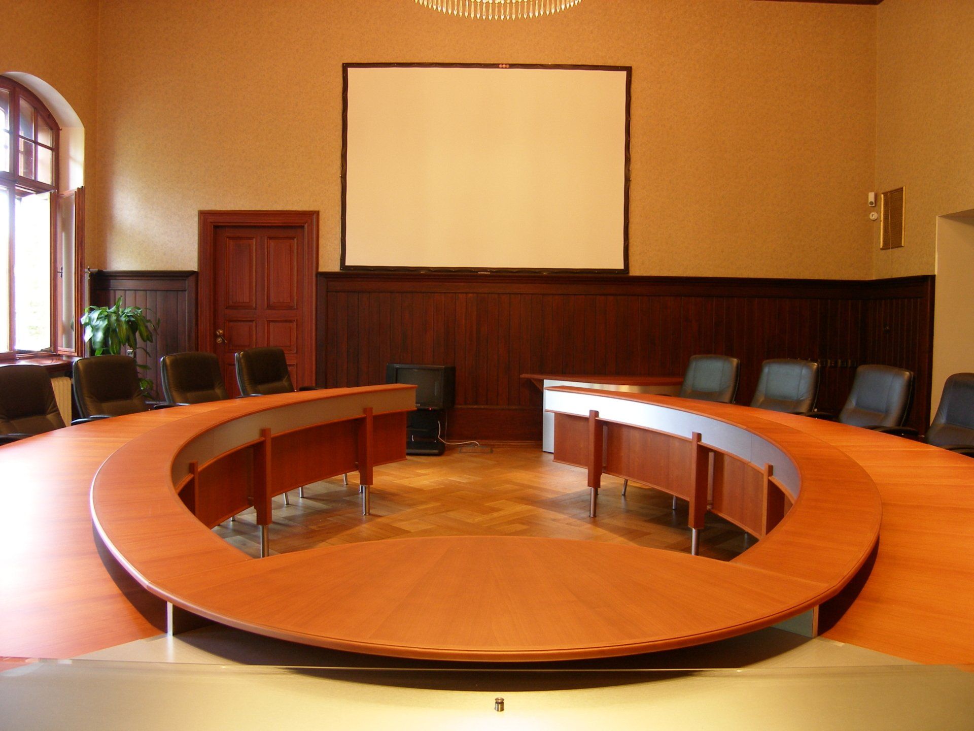 An empty conference room with a round table and chairs