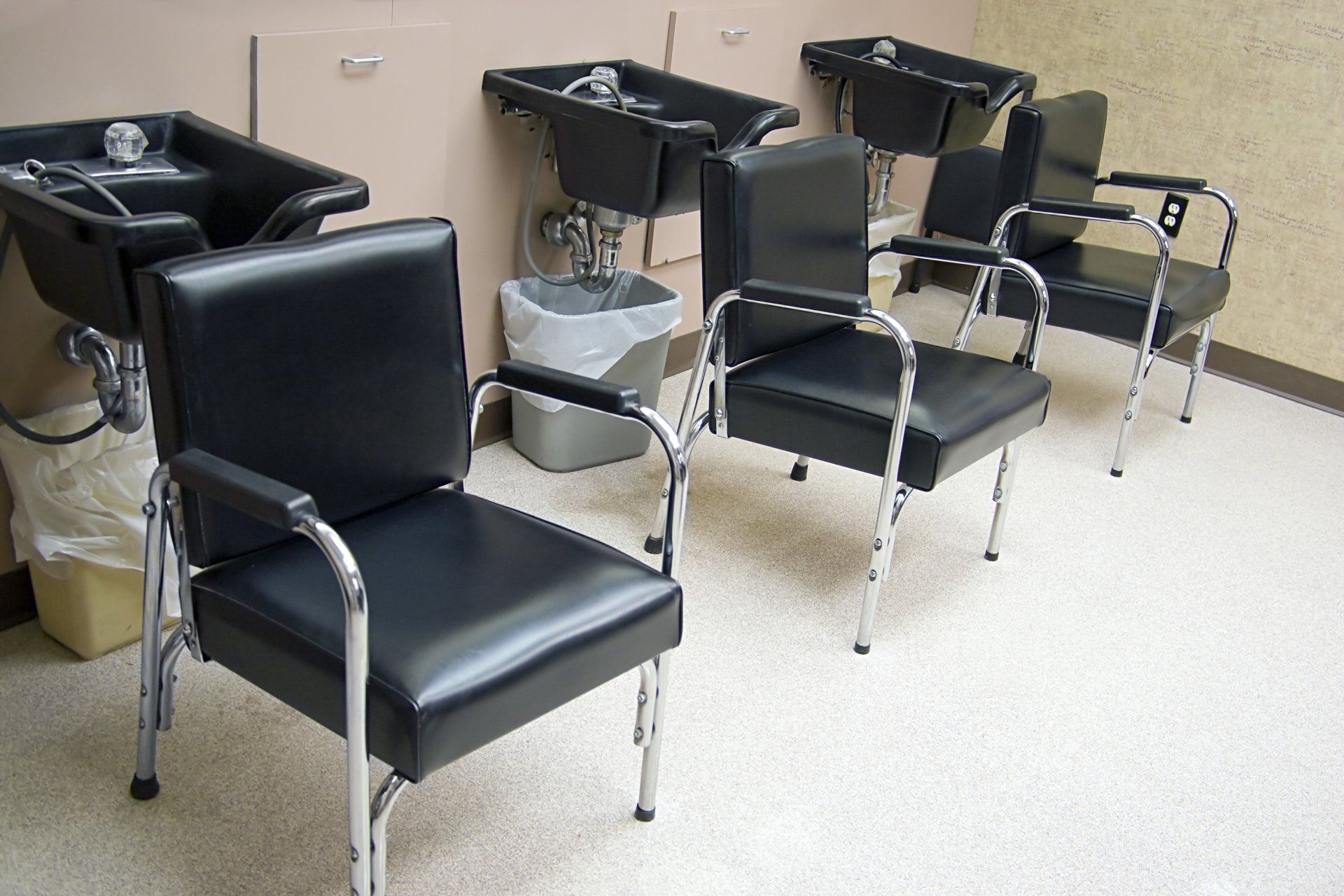 A row of chairs and sinks in a room