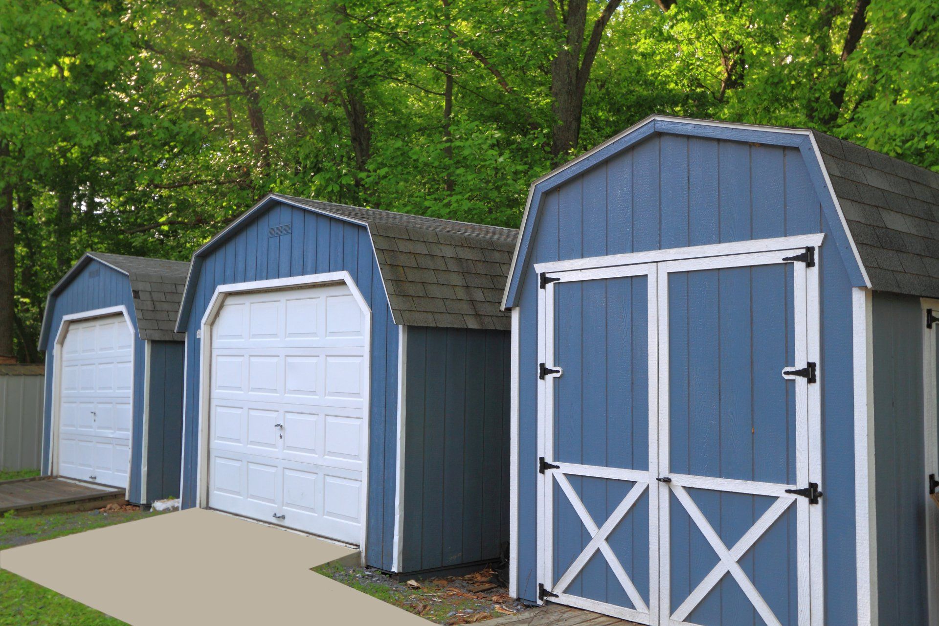 A row of blue garages with white doors are lined up next to each other.