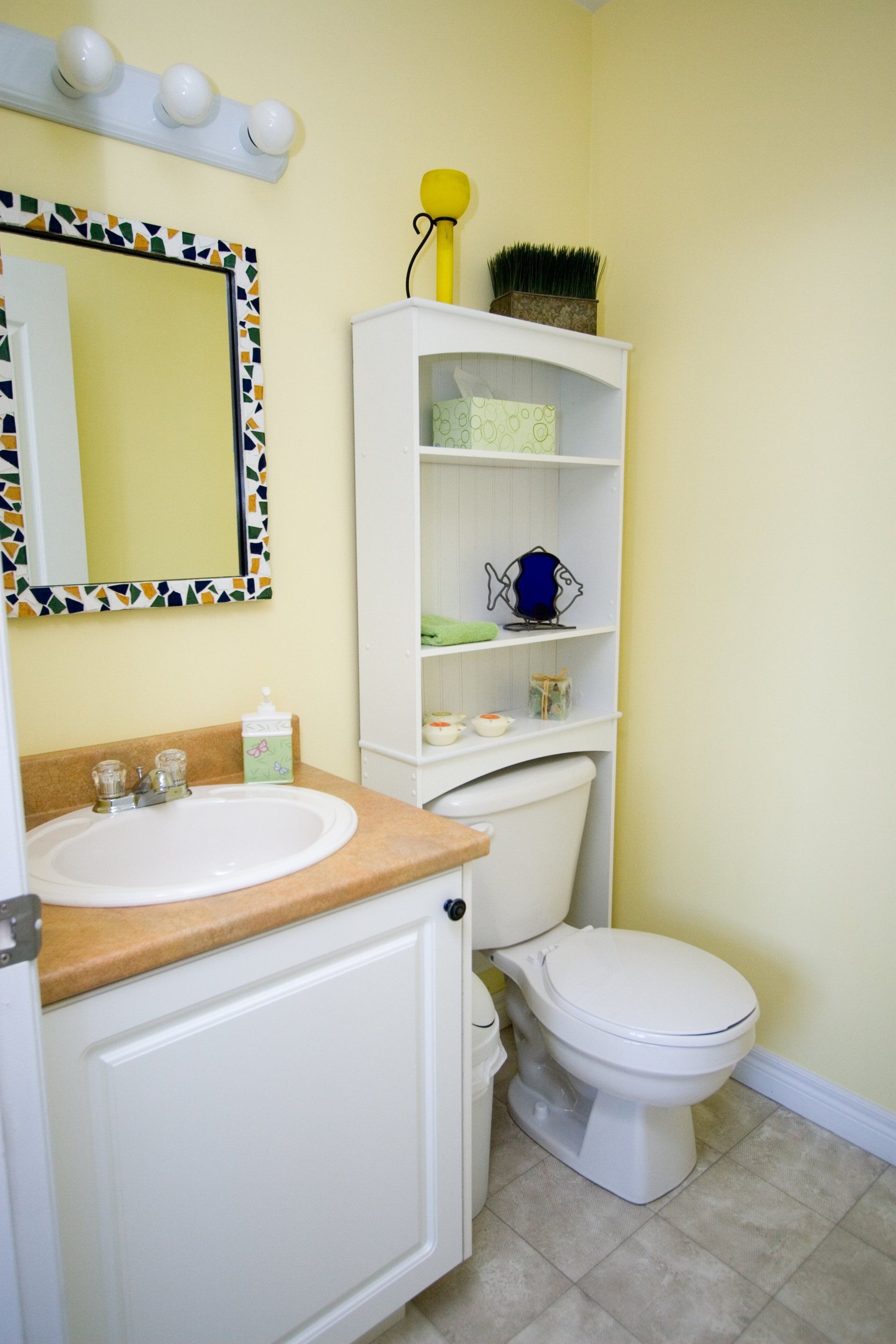 A bathroom with a toilet a sink and a mirror