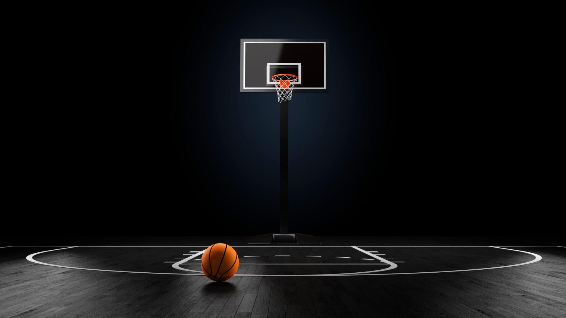 A basketball is sitting on a basketball court in front of a basketball hoop.