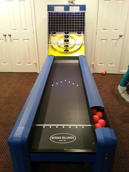 A bowling alley in a room with balls in it