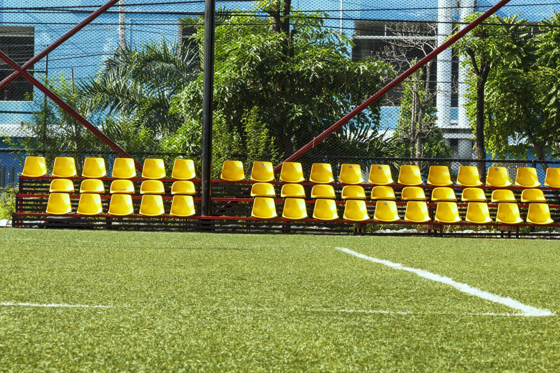 A row of yellow seats on a soccer field.