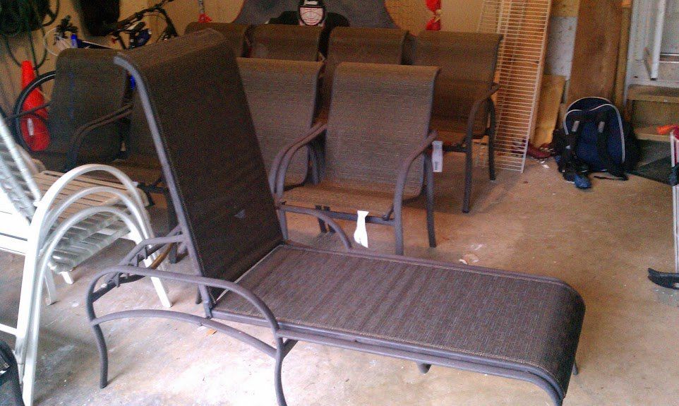 A bunch of chairs and a lounge chair in a garage