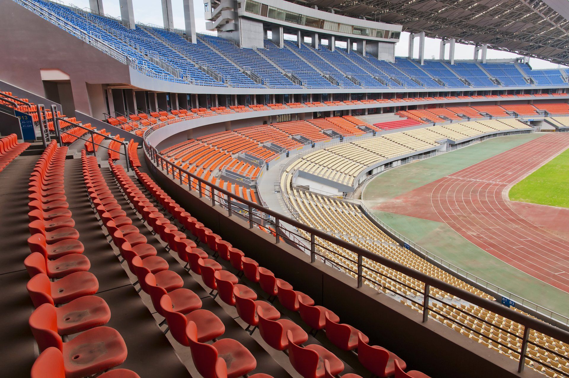 An empty stadium with rows of red and blue seats