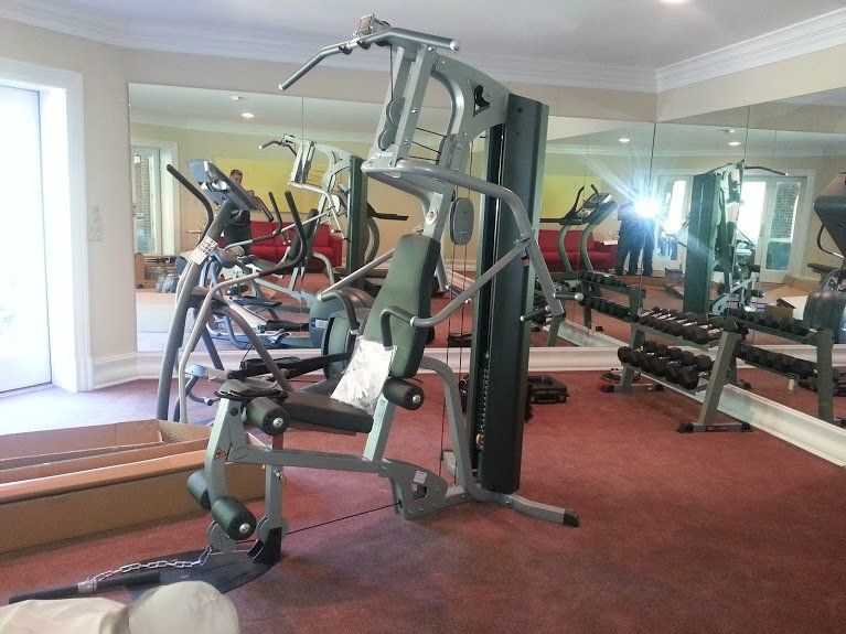 A gym with a lot of equipment and mirrors
