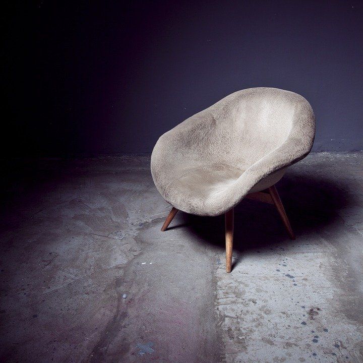 A chair is sitting on a concrete floor in a dark room
