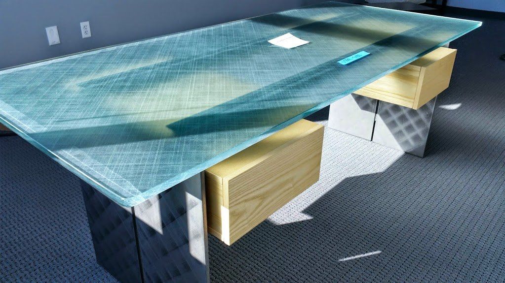 A conference table with a glass top in a room
