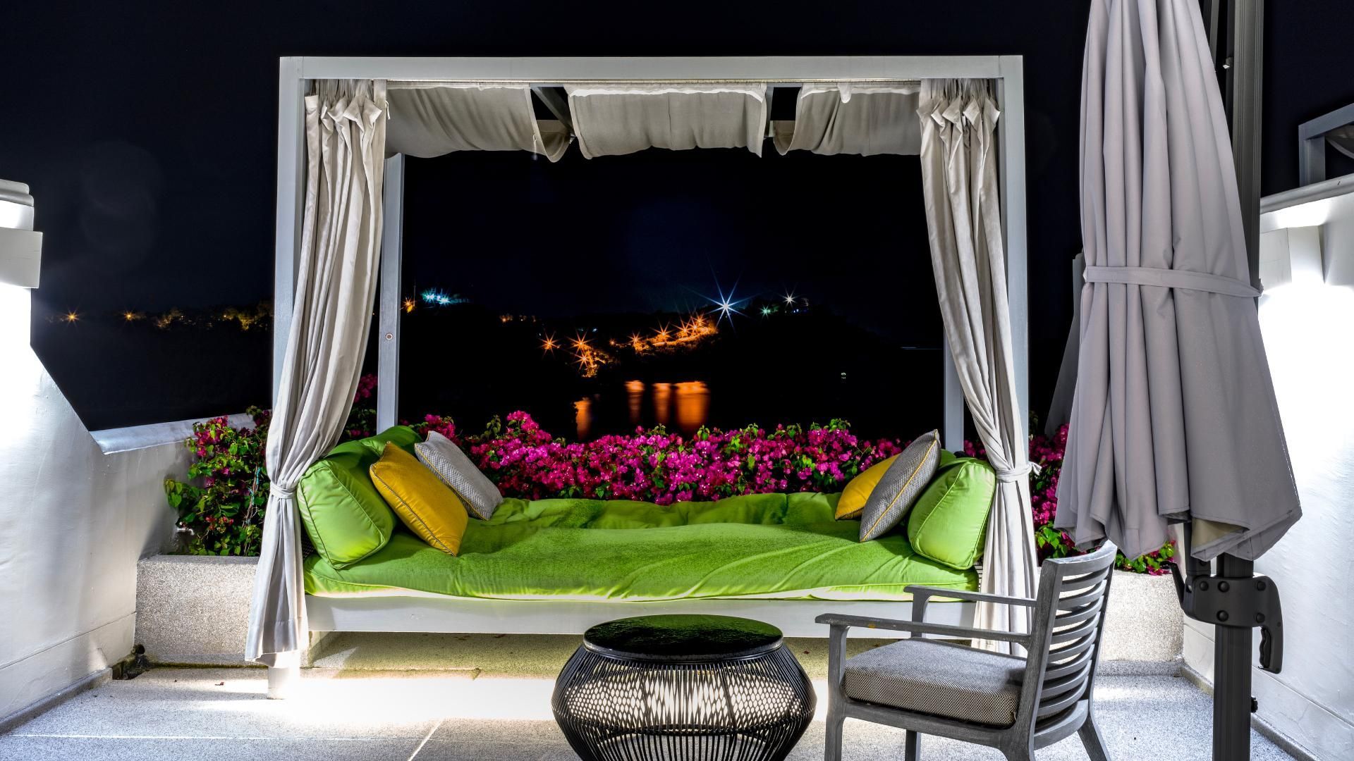 A canopy bed with a view of a city at night