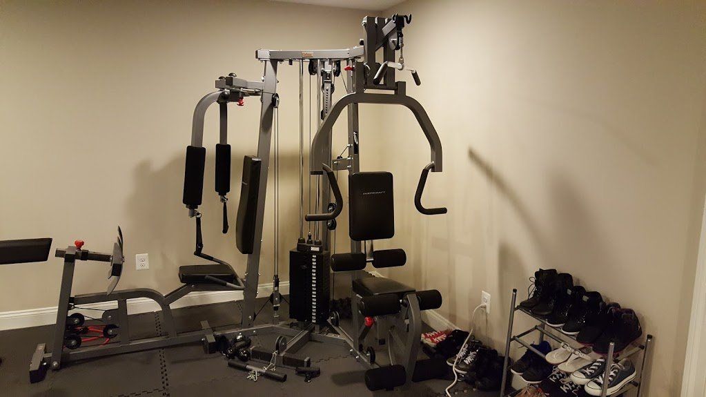 A gym with a lot of exercise equipment and a few dumbbells