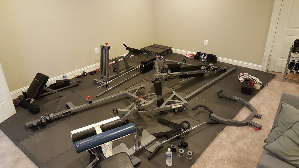 A room with a lot of exercise equipment on the floor.