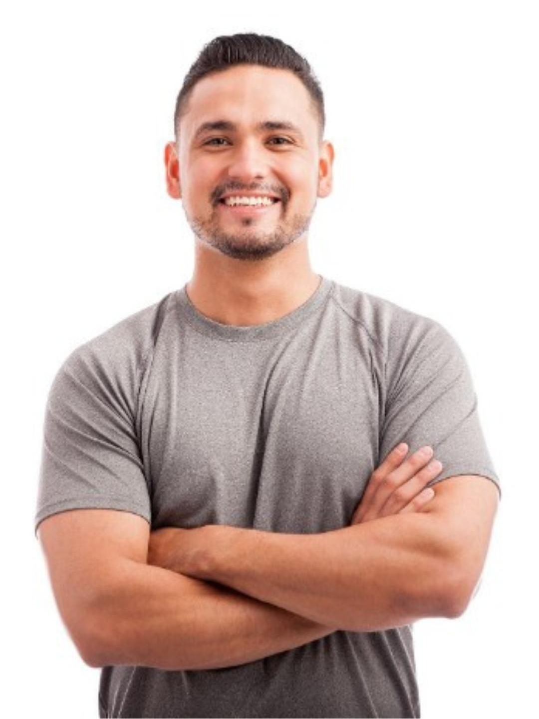 A man in a grey shirt is smiling with his arms crossed