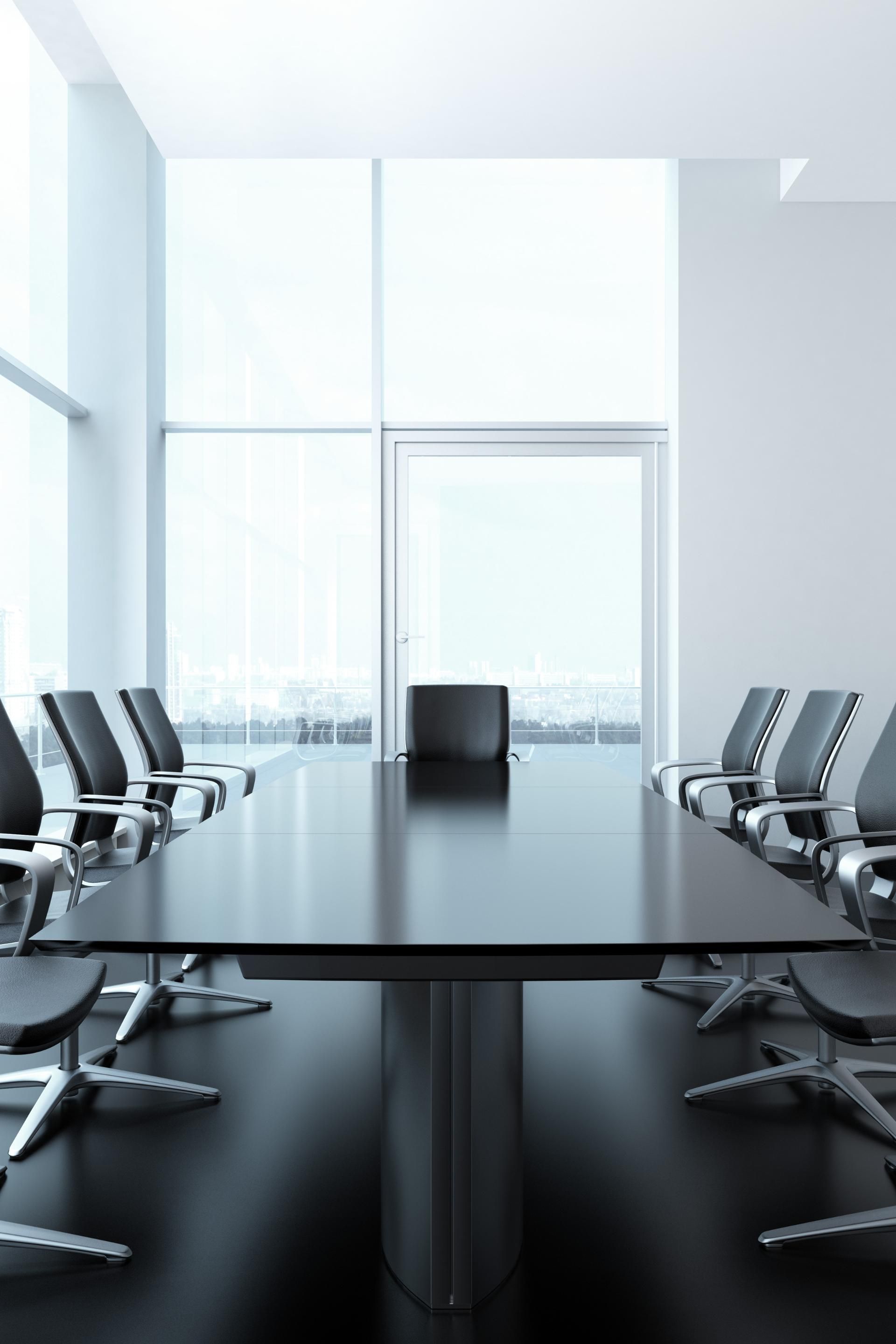 A conference room with a long black table and chairs