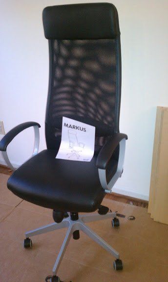 A black office chair with a paper on it that says markus