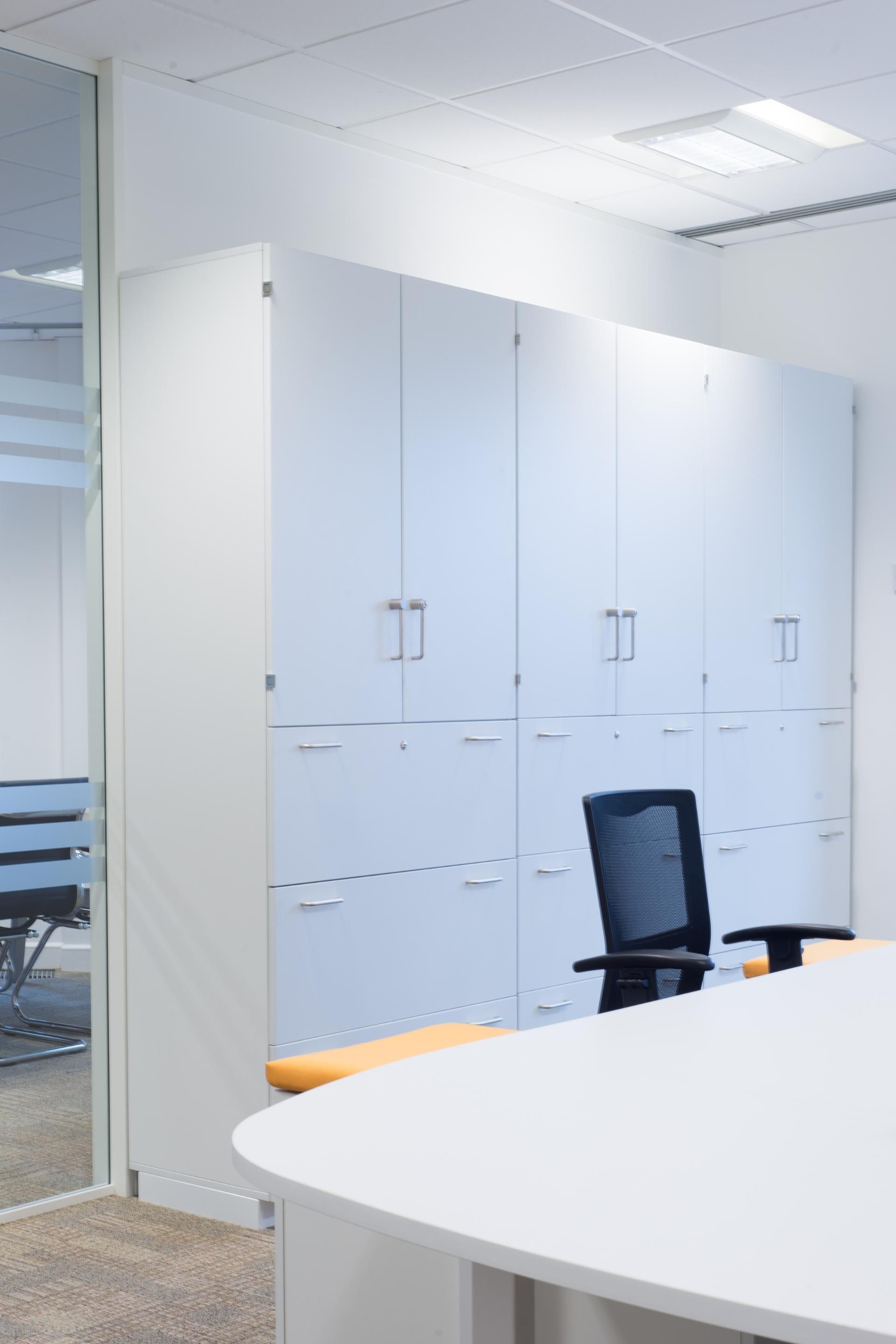 An office with a desk , chair , and cabinets.