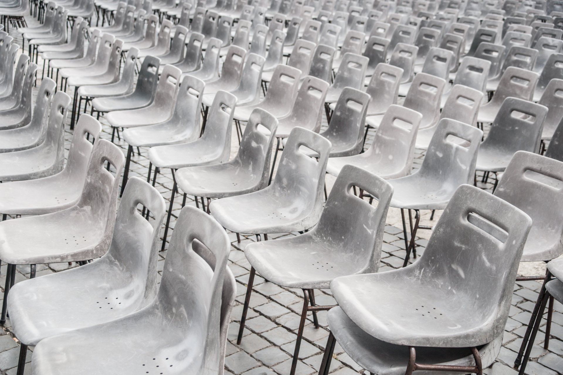 A row of empty white chairs are lined up in a row.
