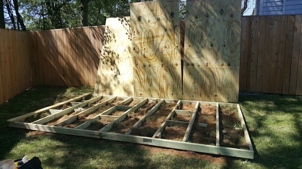 A wooden structure is being built in a backyard.