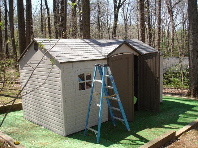 A ladder is leaning against a shed in the woods