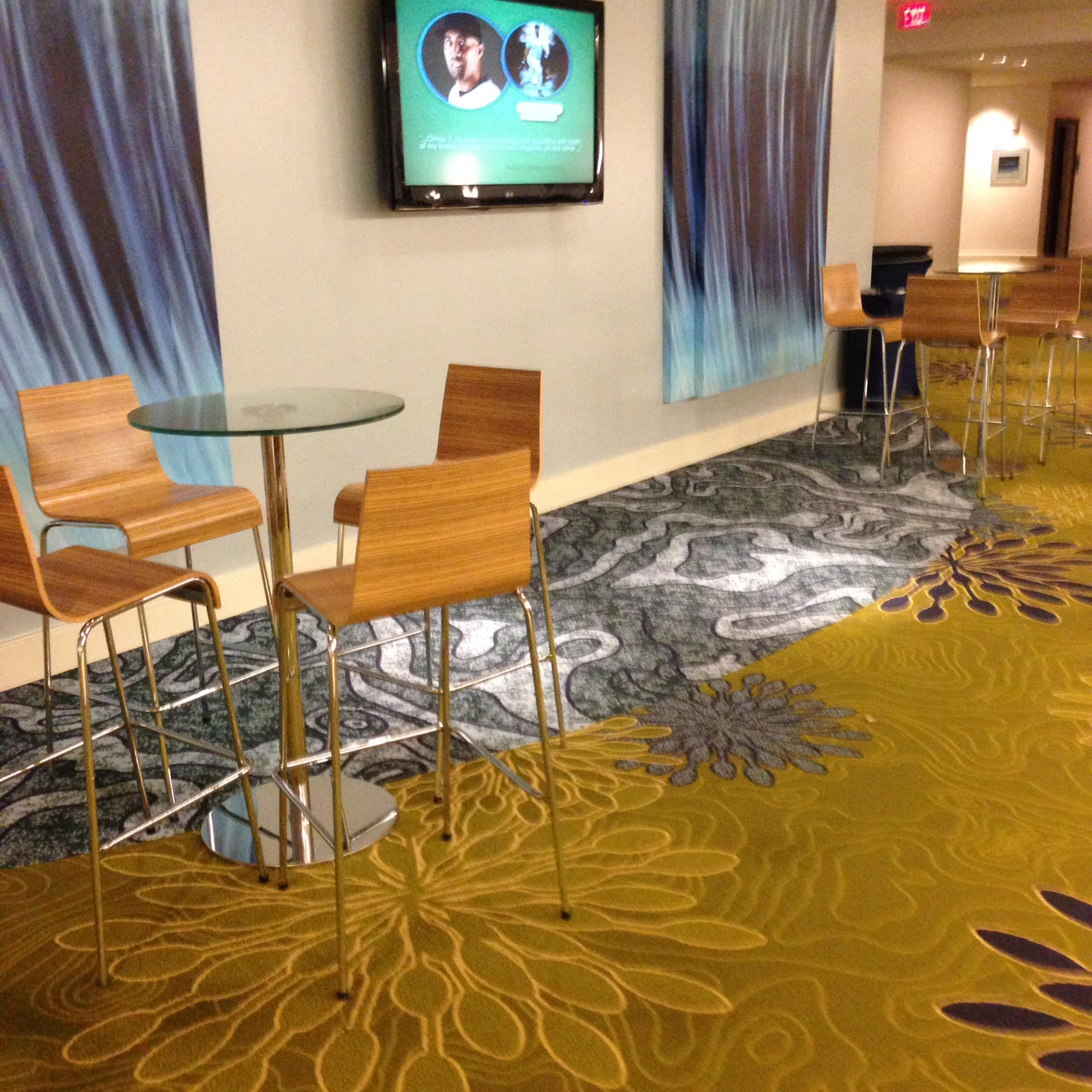 A room with a table and chairs and a tv on the wall