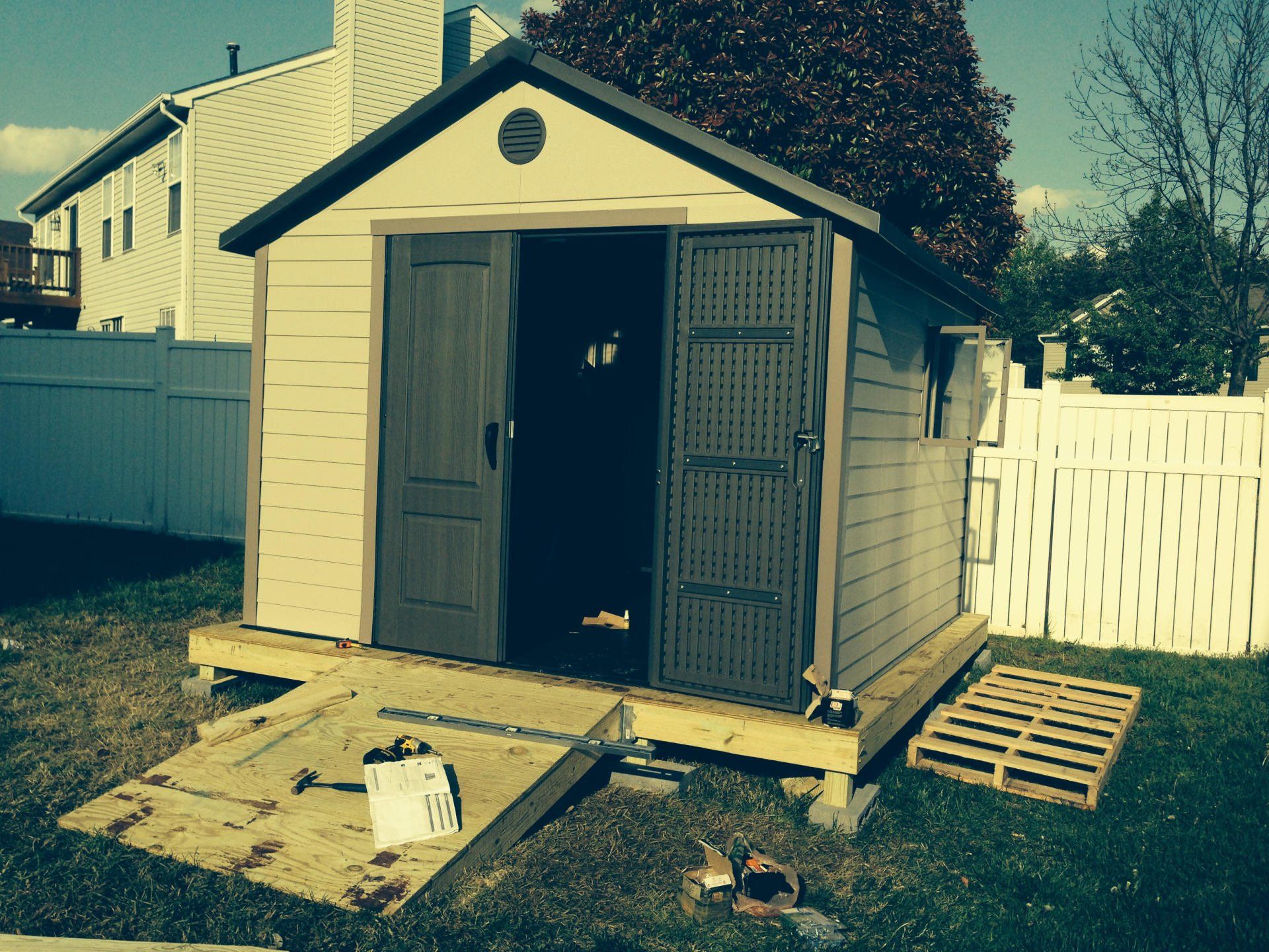 A shed in a backyard with the door open